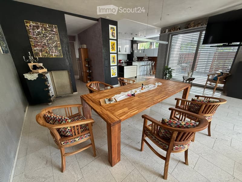 large open space, wood dining table, wooden chairs, modern decor, open door to kitchen, large windows