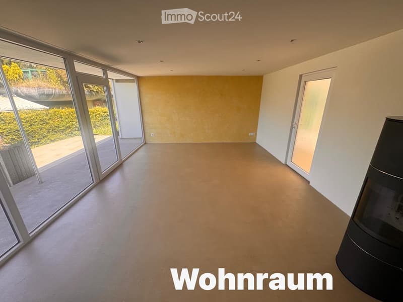 Empty room with large glass sliding doors, light-colored walls, and a smooth floor. No furniture or equipment is present.