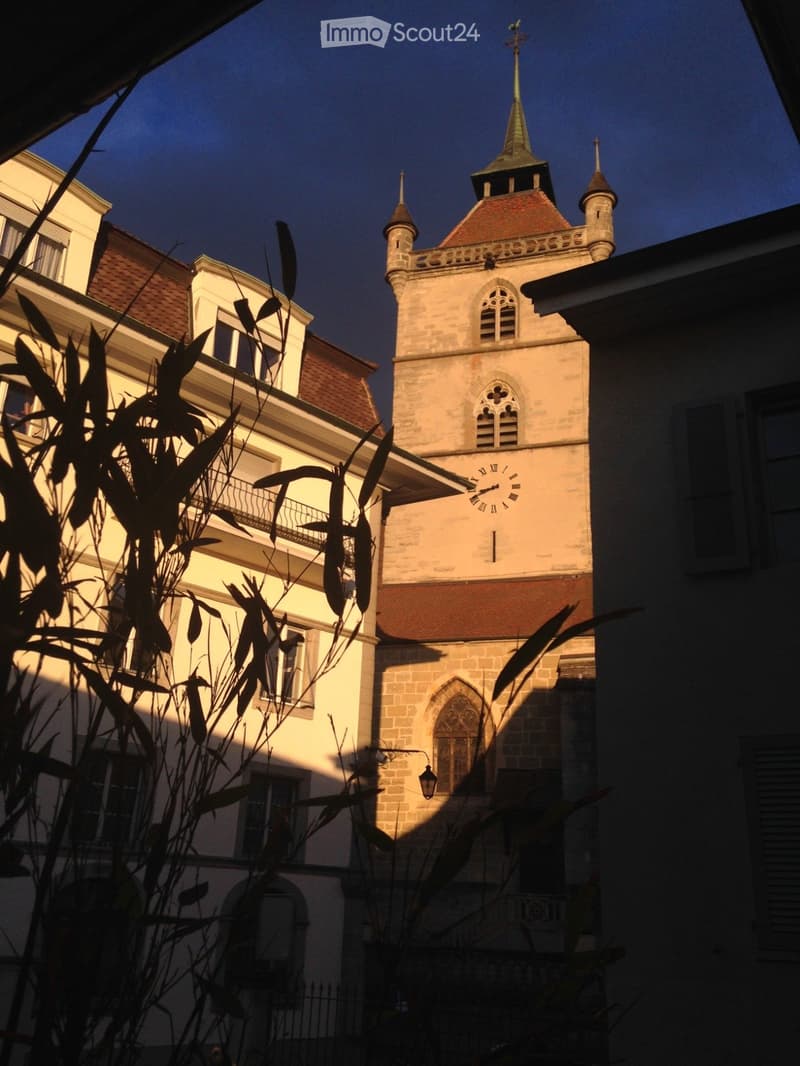 Church with a clock tower, brick walls, arched windows, and a steeple.