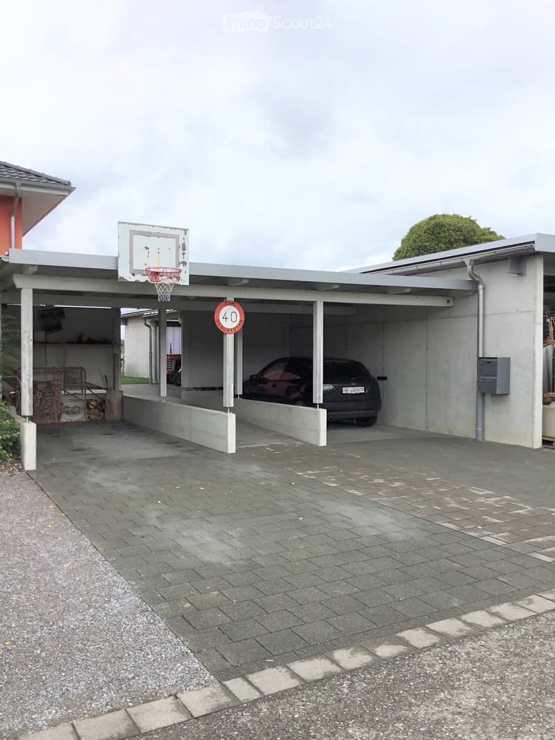 {"type": "Garage", "objects": [], "visible_features": ["Garage"], "description": "Attached garage with a covered driveway, a parked car, and a basketball hoop on the roof.", "localized_descriptions": {"EN": "Attached garage with a covered driveway, a park