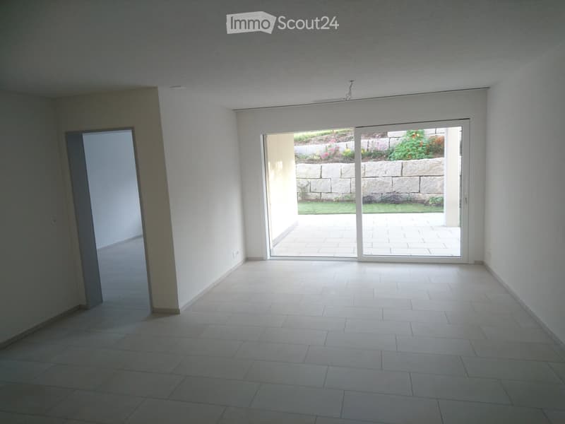 empty room with white tiled flooring, white walls, sliding glass doors leading to a terrace