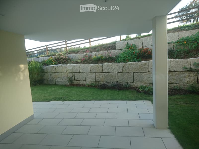 balcony with floor and pillars, garden with grass and flower plants, terrace with stone wall, view of mountains