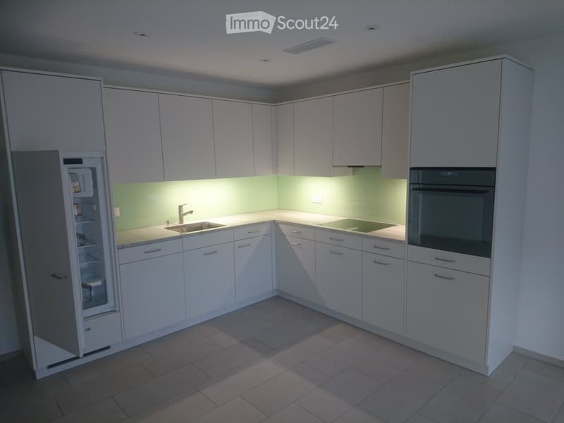 modern kitchen, white cabinets, green backsplash, stainless steel appliances, double oven, dishwasher, refrigerator, ceramic flooring
