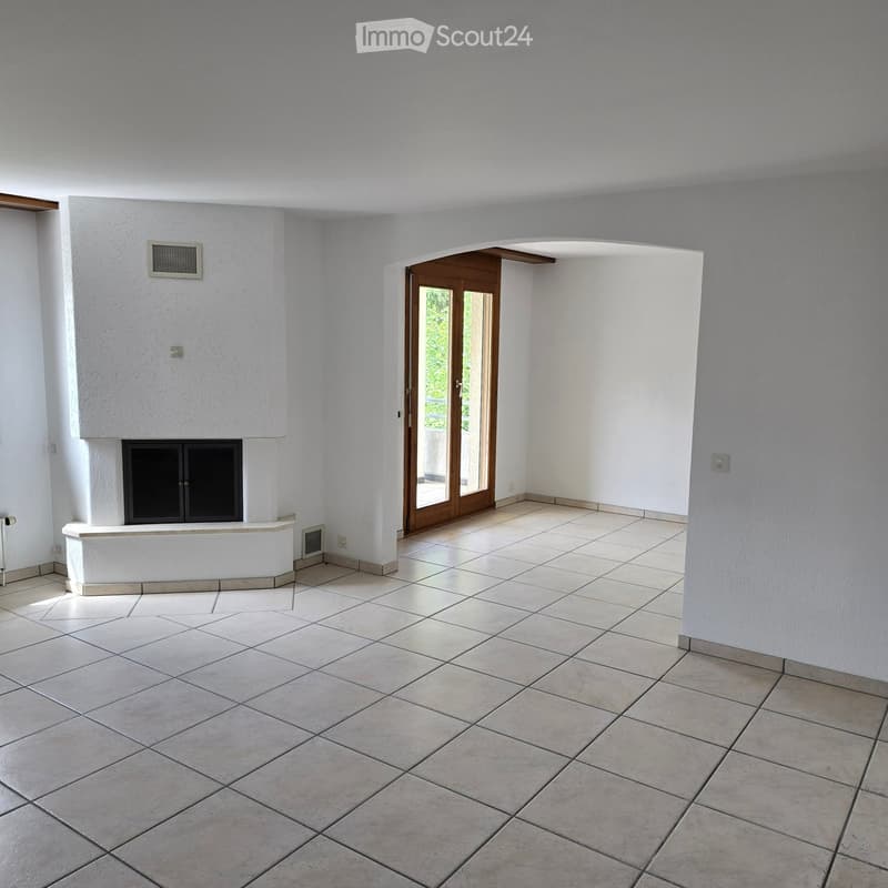 Empty room with tiled floor, white walls, and a built-in fireplace. Features a large sliding glass door leading outside.