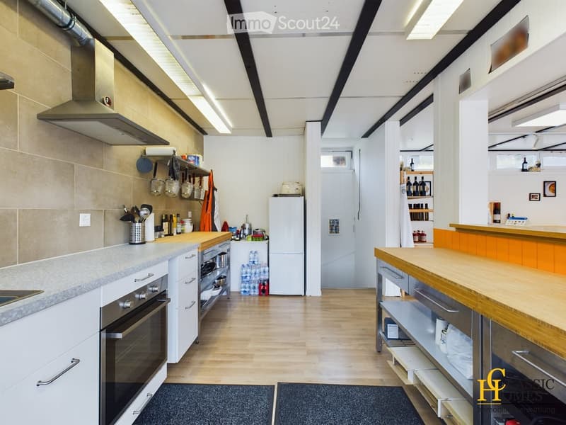 Modern kitchen with white cabinets, stainless steel appliances, wooden island, and various kitchen items on counters.