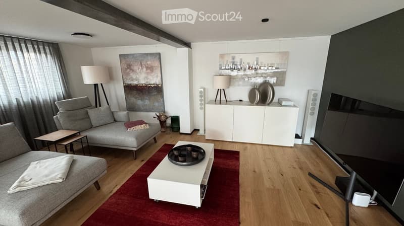 Modern living room with grey sofa, white coffee table, side table, white cabinet, and artwork on the walls.