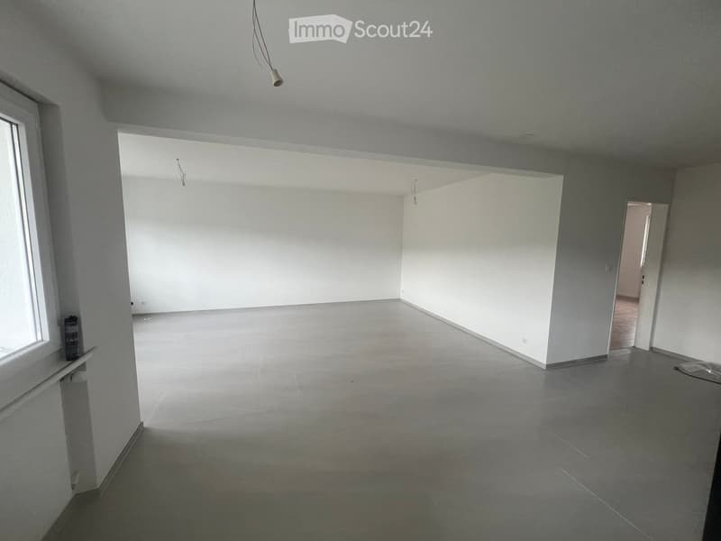 Empty room with grey tiled floor, white walls, and a single window on the left side. No furniture or equipment is present.