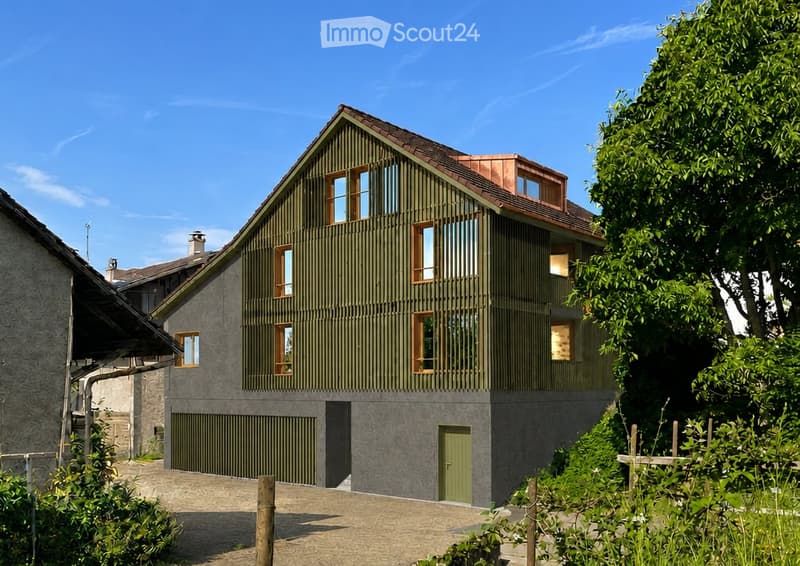 Modern two-story house with green wooden siding, multiple windows, and a garage. The house features a sloped roof with a copper-colored section and is surrounded by greenery.