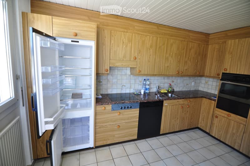 Modern kitchen with light wooden cabinets, tiled backsplash, granite countertop, and stainless steel appliances including a refrigerator, oven, and dishwasher.