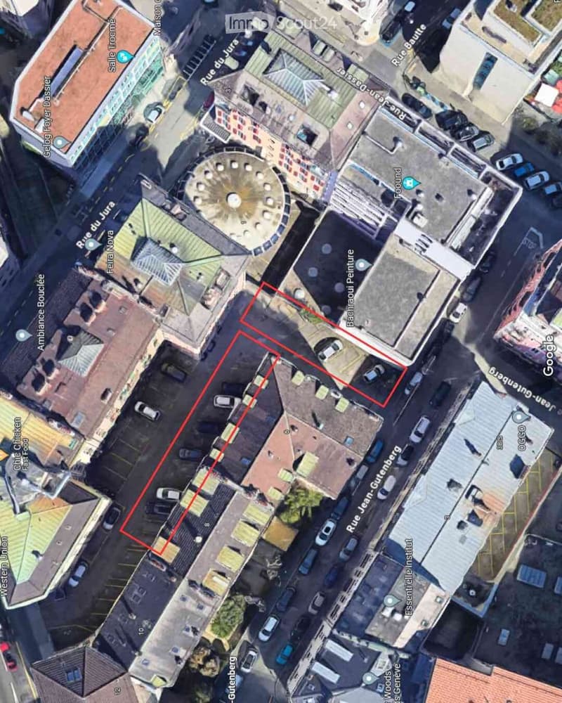 Aerial view of a city block with multiple buildings, streets, and a highlighted area in red.