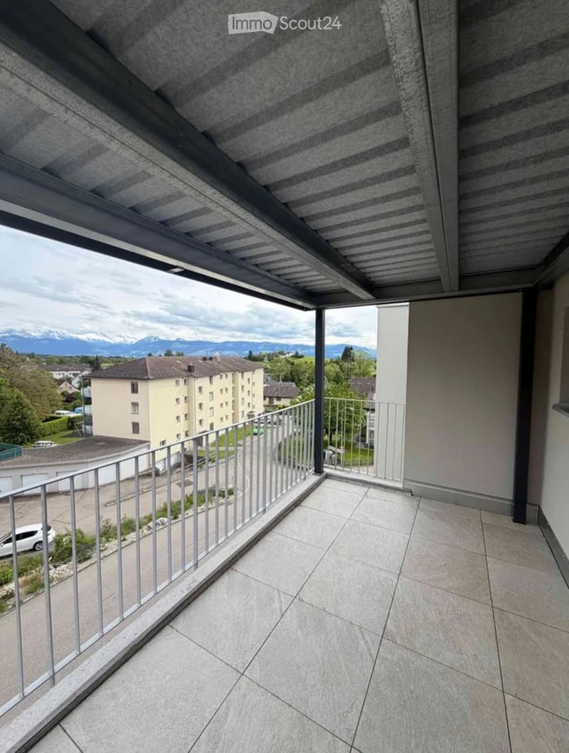 Balcony with tiled floor, metal railing, and scenic mountain view in the background.