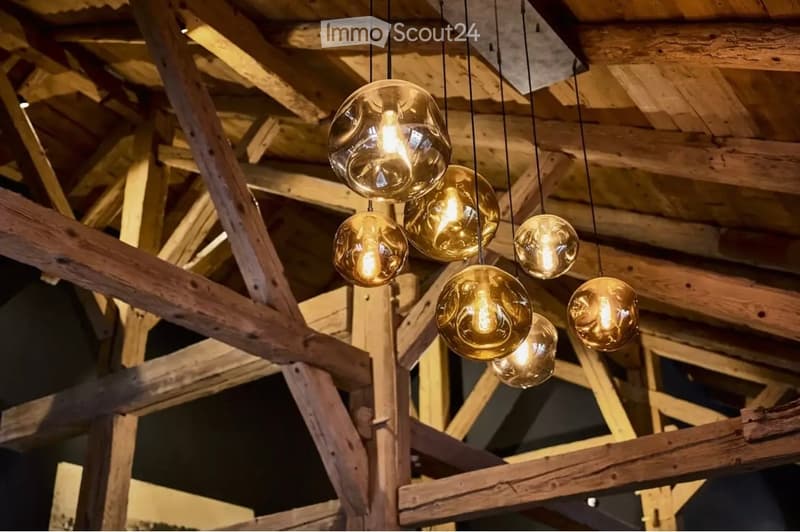 Wooden ceiling beams with exposed wooden structure and multiple hanging pendant lights with glass bulbs.