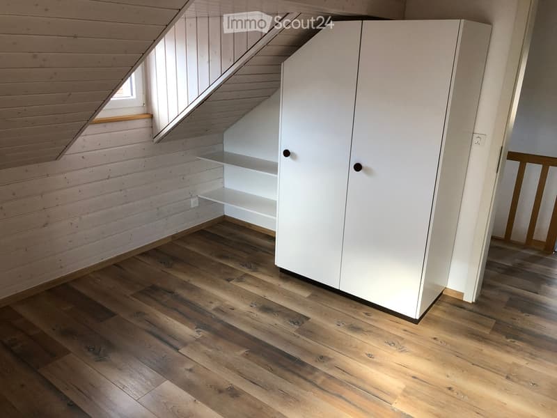 attic room, sloped ceiling, white walls, wooden flooring, white wardrobe, shelves