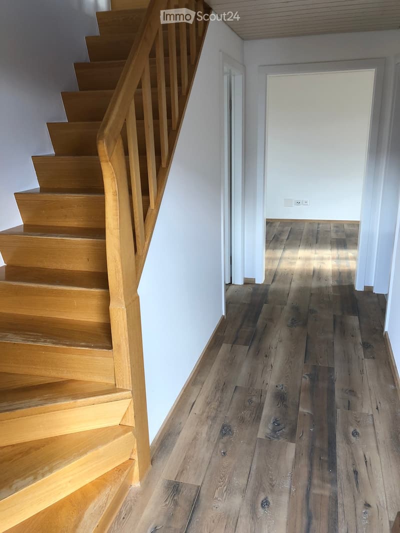 wooden staircase, hardwood floor, painted wall, door, power outlet