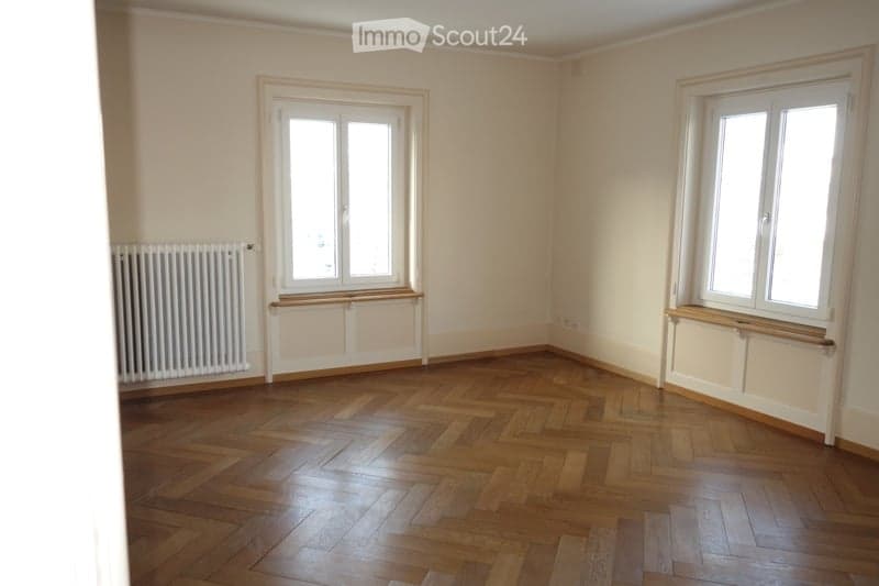 wooden floor, white walls, large windows, radiator, window sills