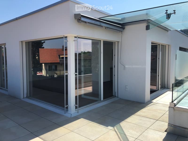 white exterior wall, sliding glass doors, terrace, raised ground floor, large glass windows, metal railings