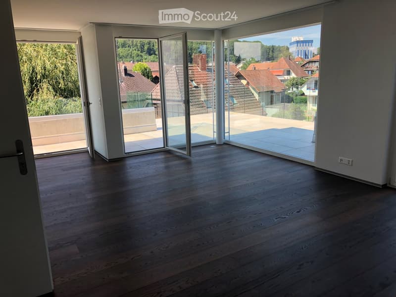 an empty room, hardwood floors, sliding doors, large windows, view of houses and trees, balcony