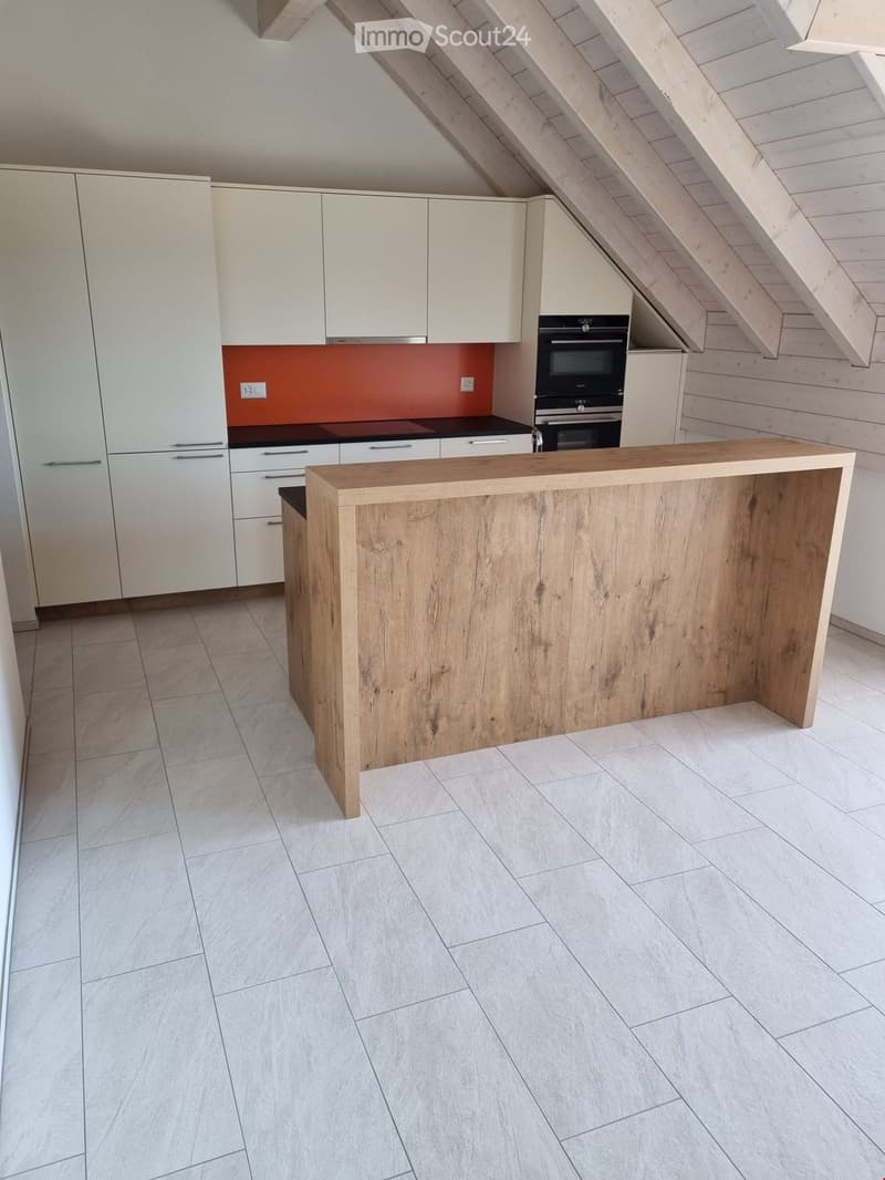 Modern kitchen with white cabinets, a wooden island, and a built-in oven. The backsplash is orange, and the floor is tiled.