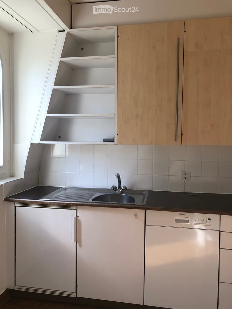 Modern kitchen with white cabinets, a sink, a dishwasher, and a countertop.