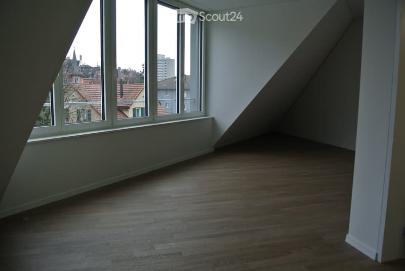 Empty room with large window offering cityscape view, wooden floor
