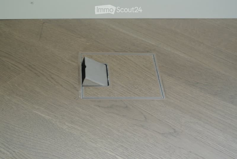 Wooden floor with a square cut-out for a floor socket.