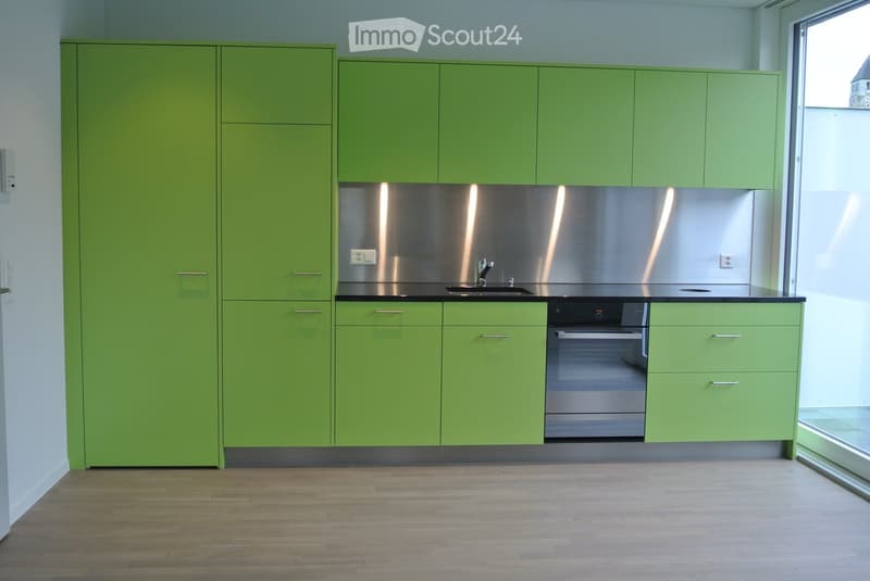 green cupboards, black counter top, silver stainless steel backsplash, silver oven, silver dishwasher, white floor
