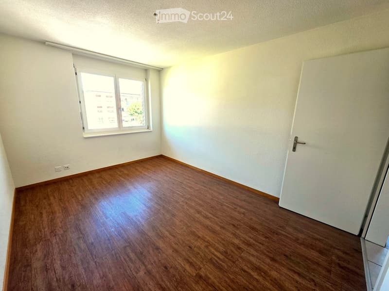 Empty room with wooden flooring, white walls, and a window with blinds. No furniture or equipment is present.