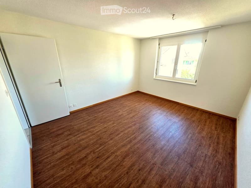 Empty room with wooden flooring, white walls, and a window with blinds. No furniture or equipment is present.