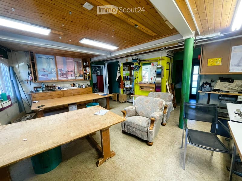 workshop with wooden tables, chairs, cabinets, posters, and various tools and equipment