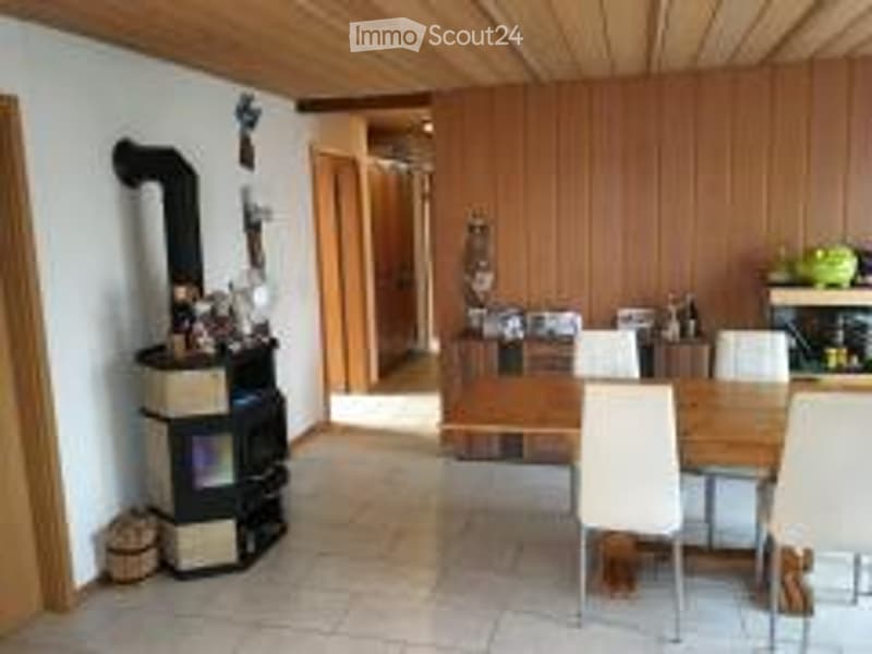 Cozy room with wooden ceiling, fireplace, dining table, and chairs.