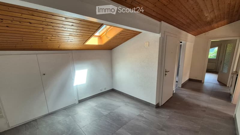 Empty room with wooden ceiling, tiled floor, white walls, and a skylight window. No furniture or equipment present.
