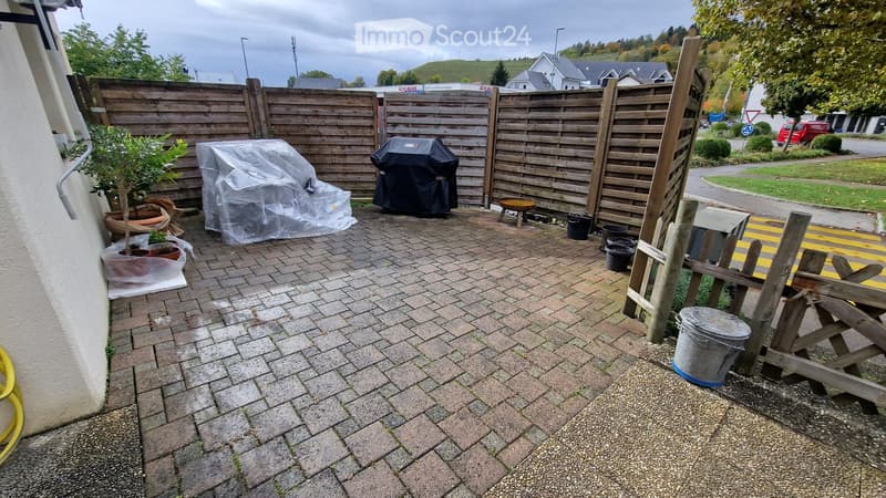 brick paved garden, wooden fences, covered grill, potted plants, buckets, covered furniture