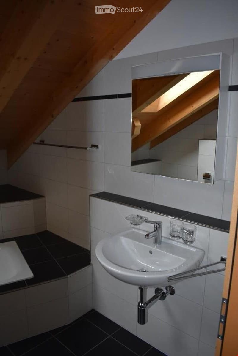 Bathroom with white tiles, white sink, mirror, bathtub, wooden ceiling