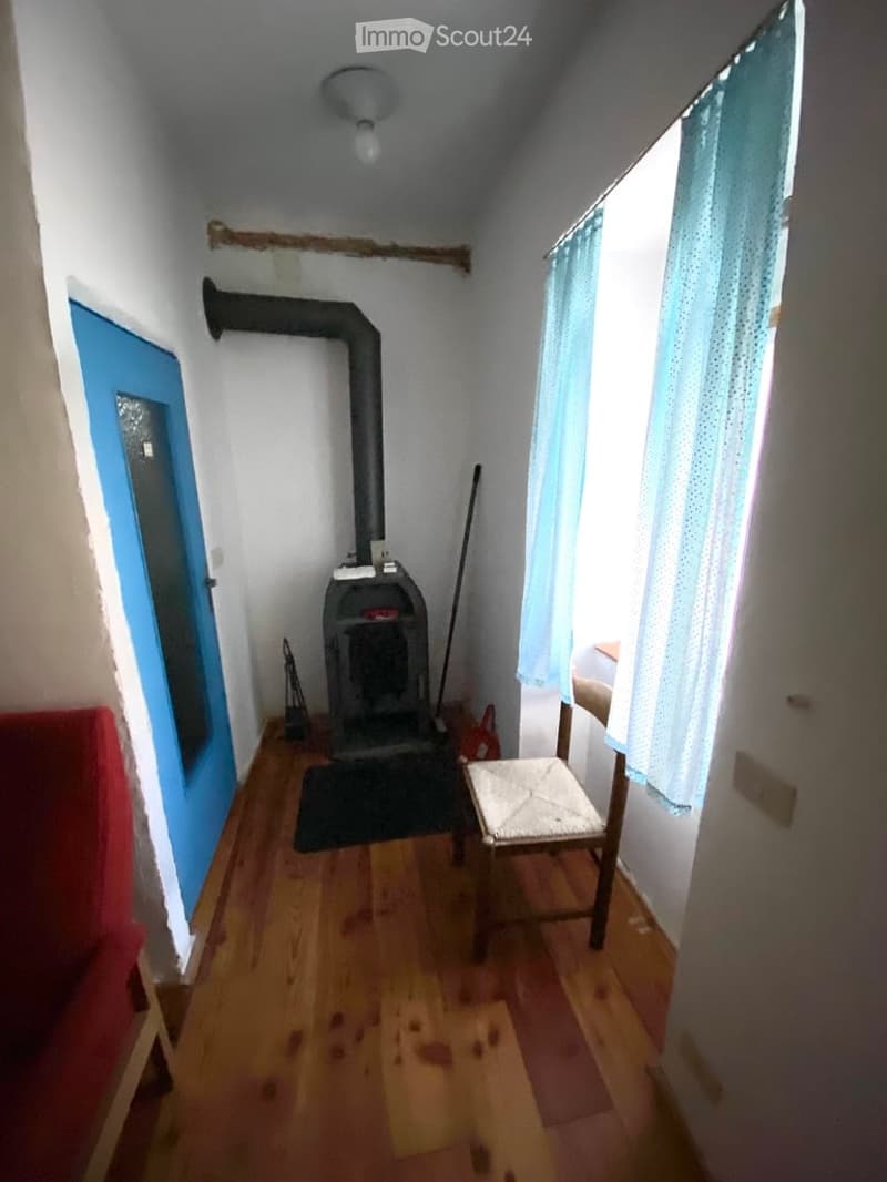 wooden floor, blue door, fireplace, wooden chair, blue curtains
