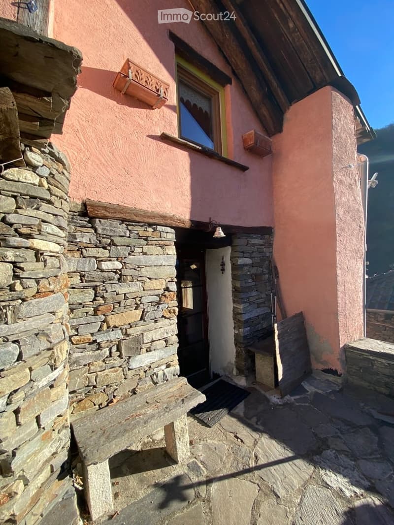 Stone wall, wooden door, window, lamp, bench, stone floor