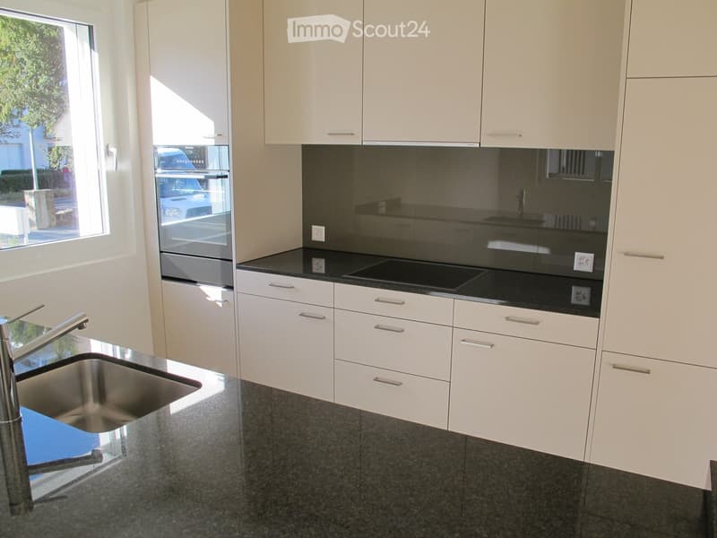 modern kitchen with white cabinets, granite countertops, gas stove, oven, sink, faucet, window