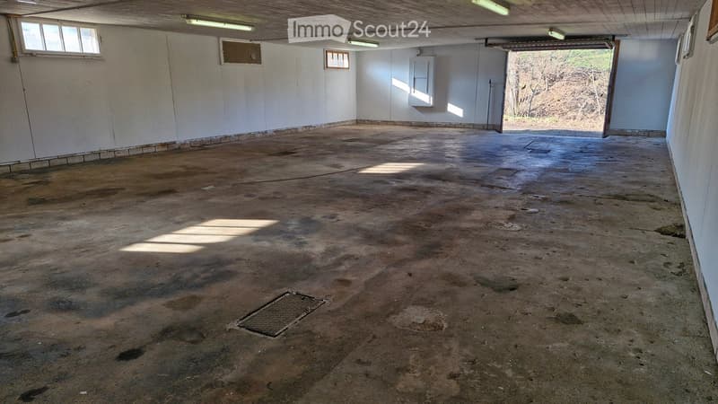 Empty room with concrete floor, white walls, and fluorescent lighting. No furniture or equipment present.