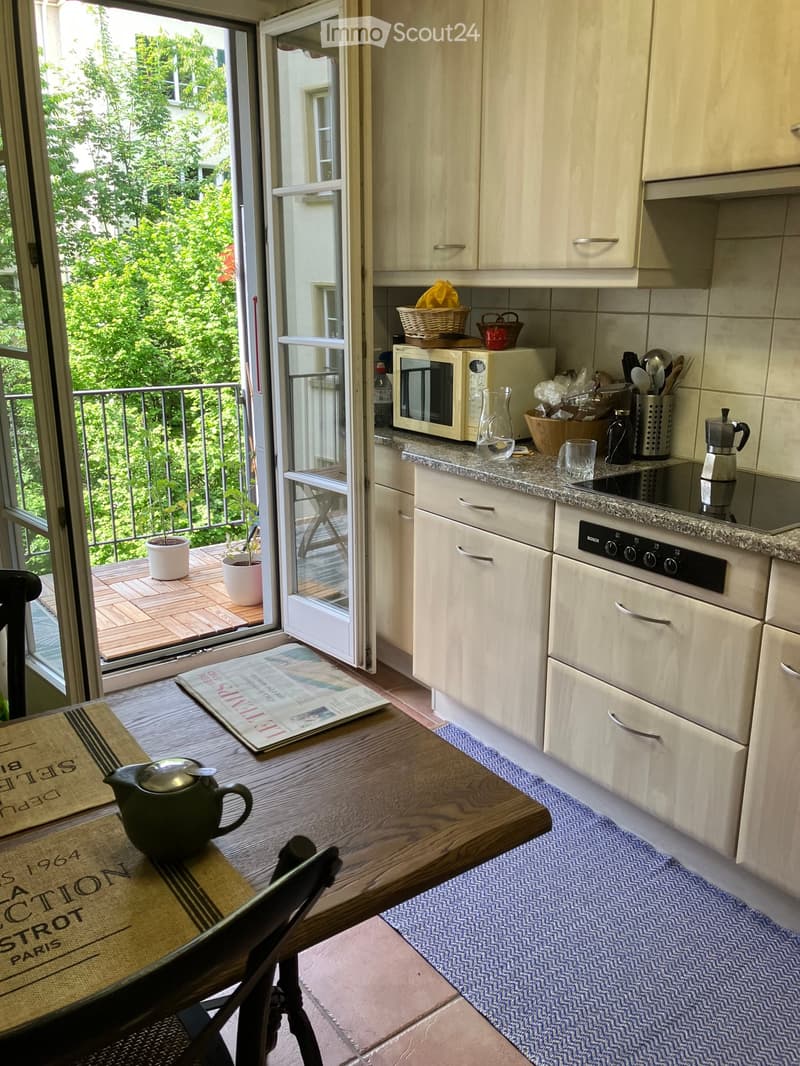 {"visible_features": ["Balcony / Terrace"], "type": "Kitchen", "objects": ["microwave", "oven", "cupboard", "table", "chair", "teapot", "cup", "oven", "stool", "cupboard", "cupboard", "cupboard", "cupboard", "cupboard", "cupboard", "cupboard", "cupboard",