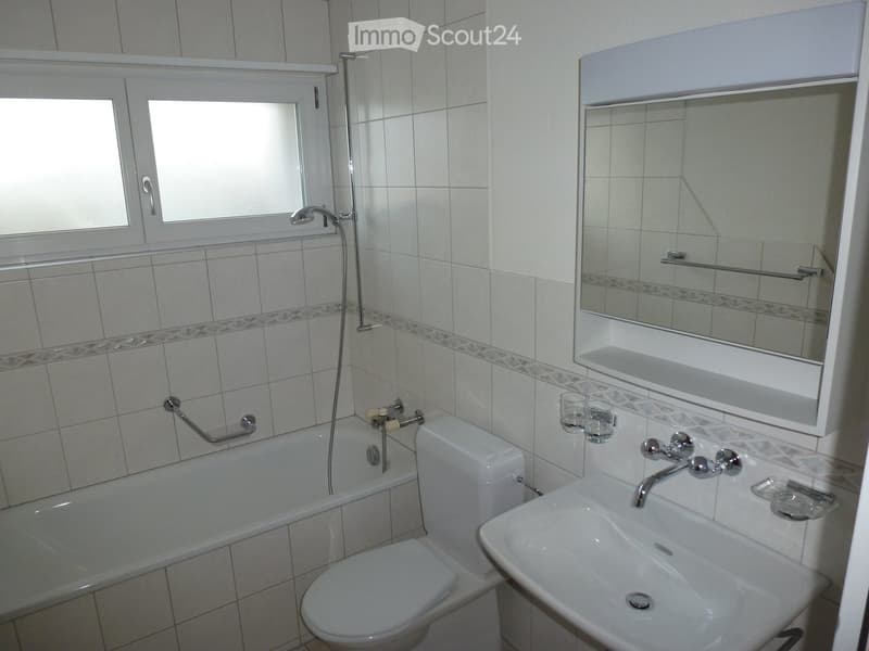Bathroom with white tiles, bathtub, toilet, sink, mirror, and shower
