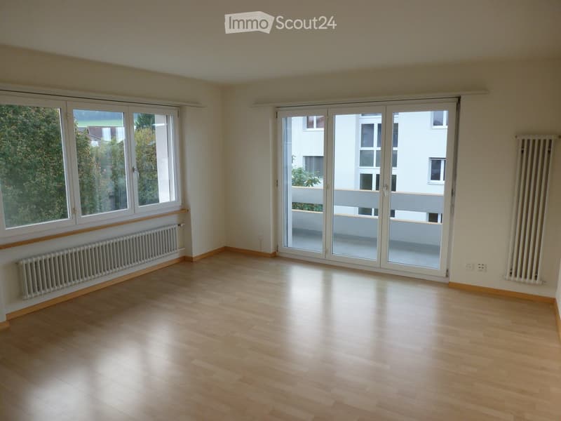 empty room, wooden floor, white walls, large windows, sliding glass doors to balcony