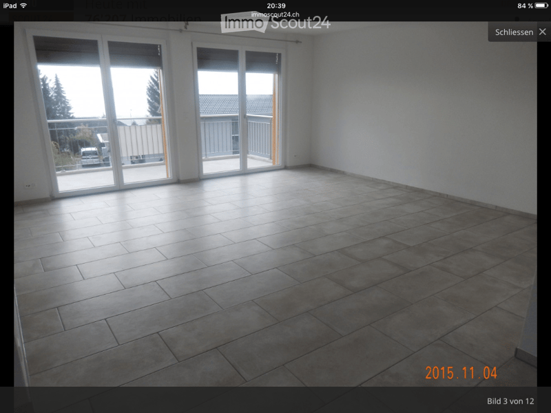 Empty room with tiled floor and large sliding glass doors leading to a balcony area.