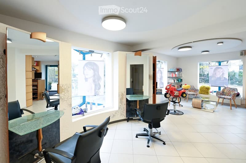 Modern salon with white tiled floors, glass reception desk, multiple chairs, mirrors, shelves with products, and decorative items including a small motorcycle and colorful cushions.