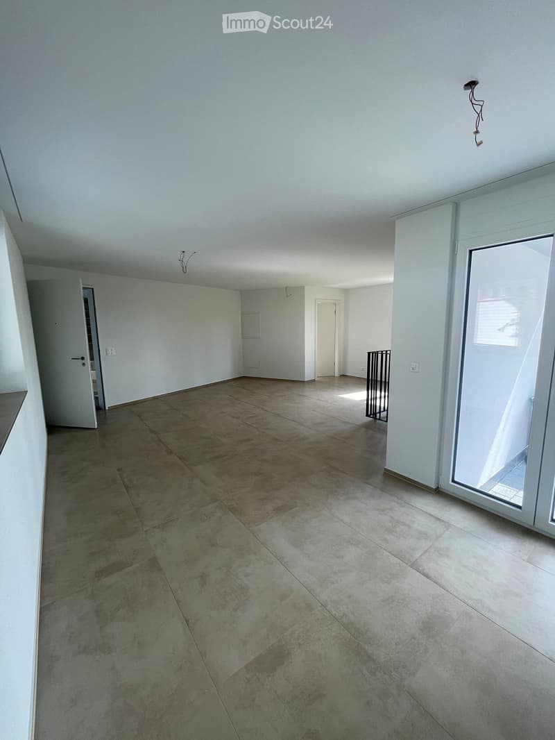 Empty room with tiled floor, white walls, and large sliding glass door leading to an outdoor area. No furniture or equipment visible.