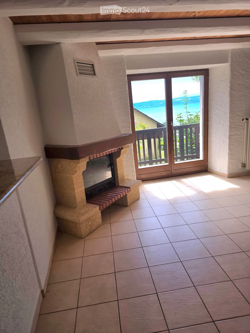 tiled floor, fireplace, sliding glass door, balcony, view of the sea