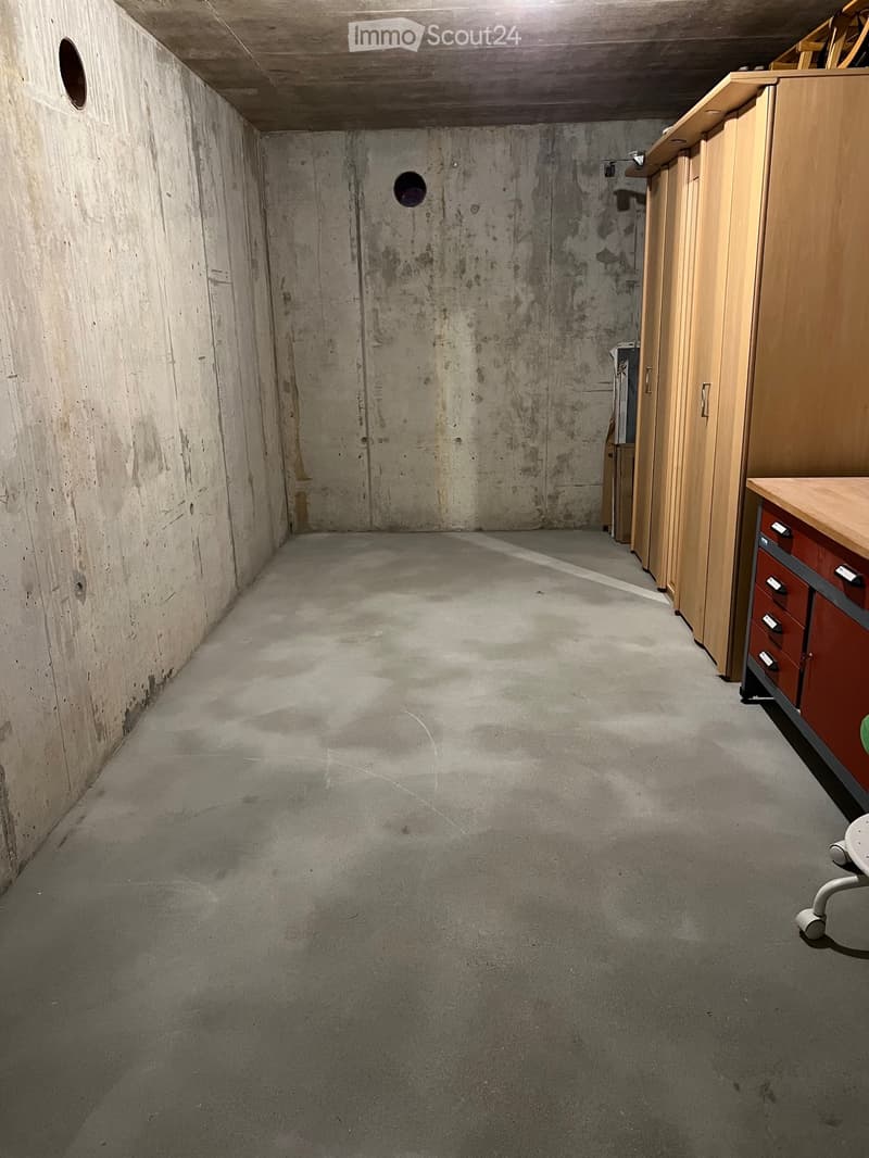 Concrete floor, wooden cabinet, metal stool, holes on walls