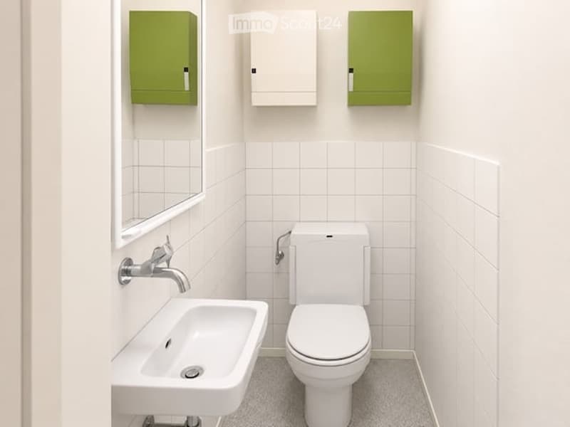 Modern bathroom with white tiles, a toilet, a sink, a mirror, and green and white cabinets.