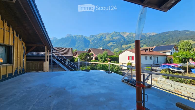 Roof terrace with a concrete surface, metal railing, and a scenic mountain view in the background.