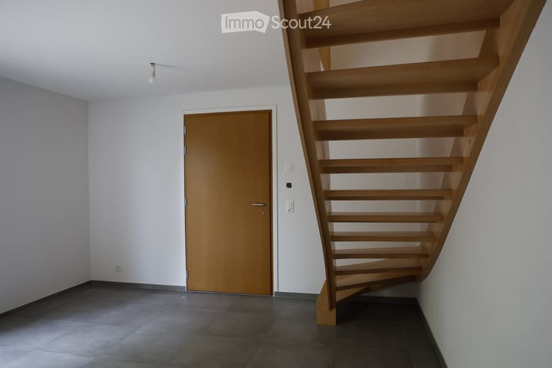 Empty room, wooden door, wooden staircase, tiled floor, white walls, light fixture