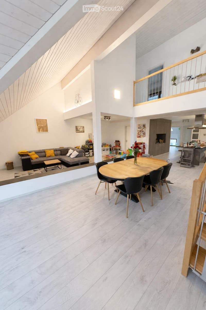 open plan living and dining area, wooden dining table, black chairs, white flooring, large windows, balcony