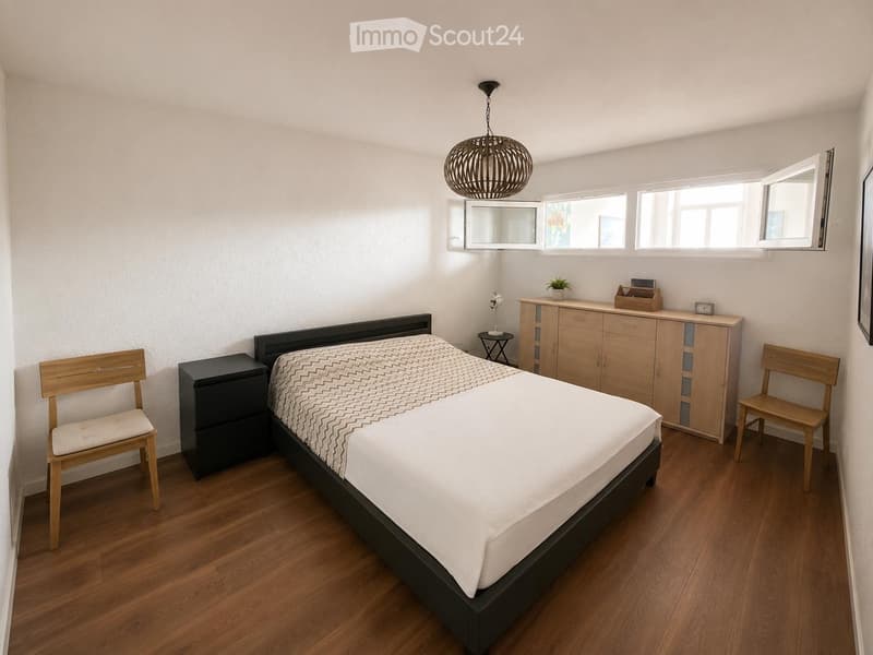 Modern bedroom with a wooden bed, nightstand, two wooden chairs, a cabinet, a mirror, a small table, and a potted plant. The room features wooden flooring and large windows with blinds.